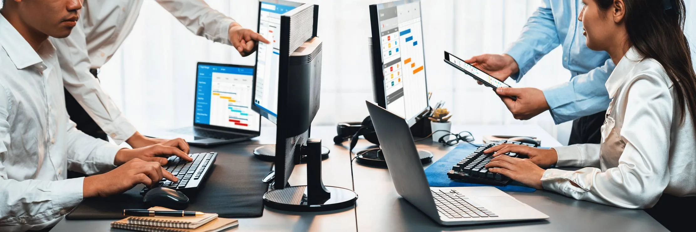 Team of professionals implementing digital business systems across multiple screens and devices