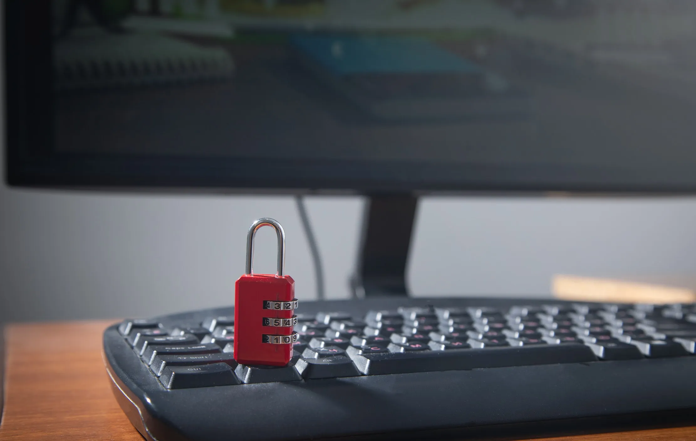 Red padlock resting on a computer keyboard, representing the need to change shared passwords after staff changes