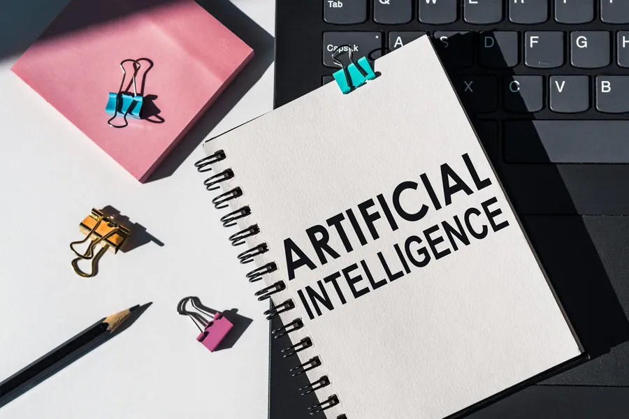 Notebook and laptop with artificial intelligence notes and tools, representing AI policy and data-flow review
