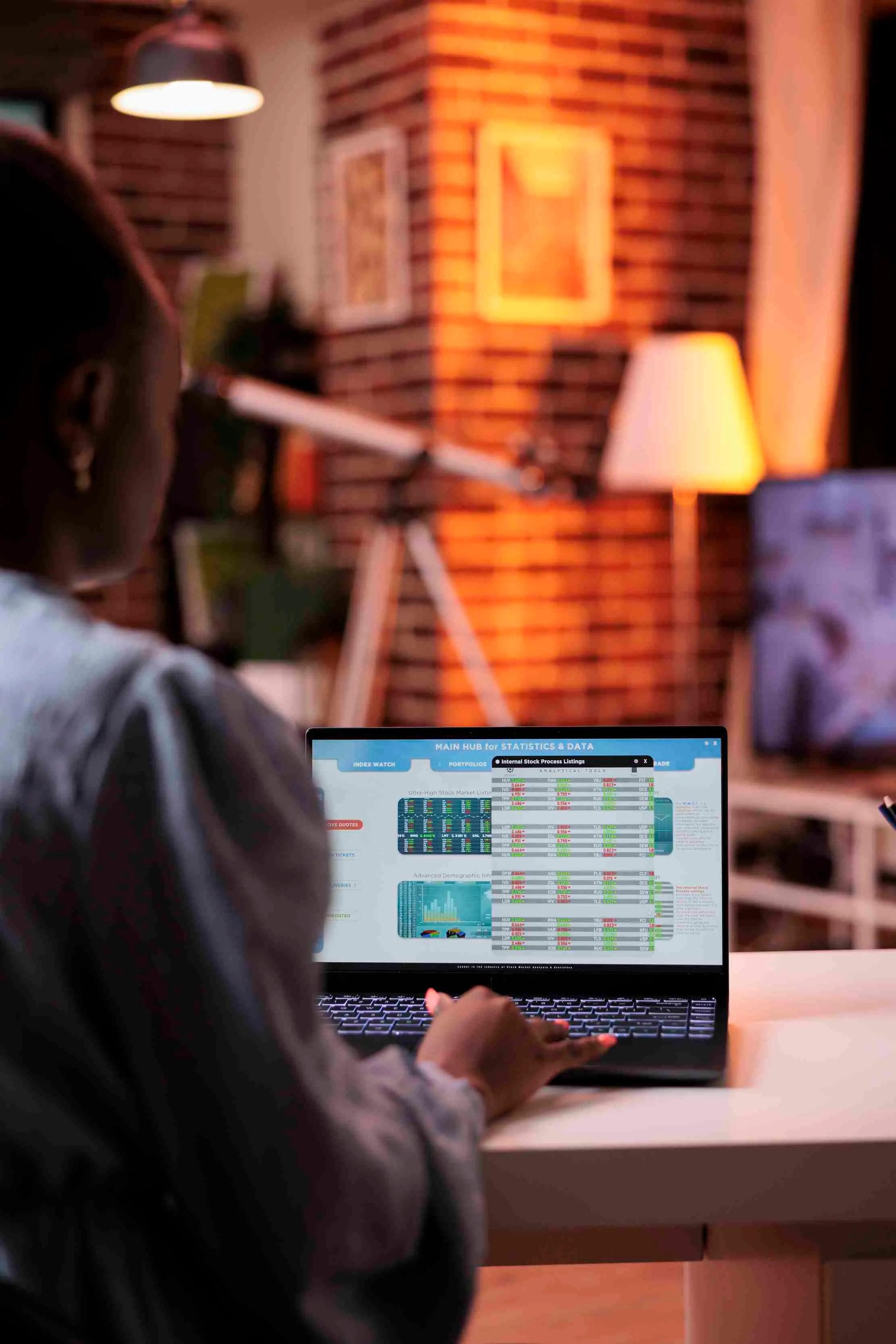 African entrepreneur reading revenue statistics and charts on laptop