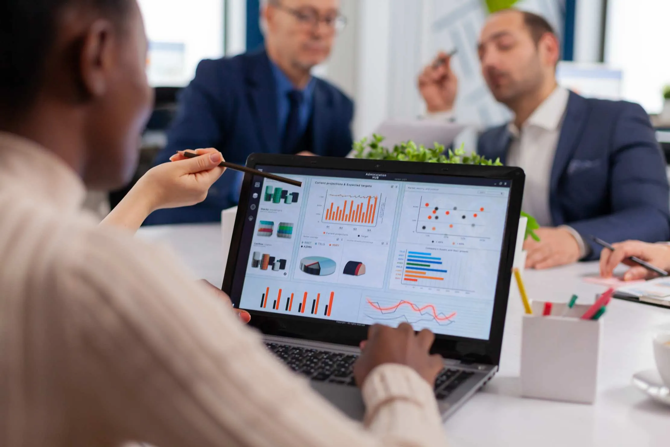 Diverse business team in boardroom discussing dashboards and project metrics