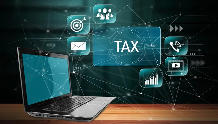 Laptop displaying a tax concept over a connected digital network, representing electronic invoicing and reporting compliance
