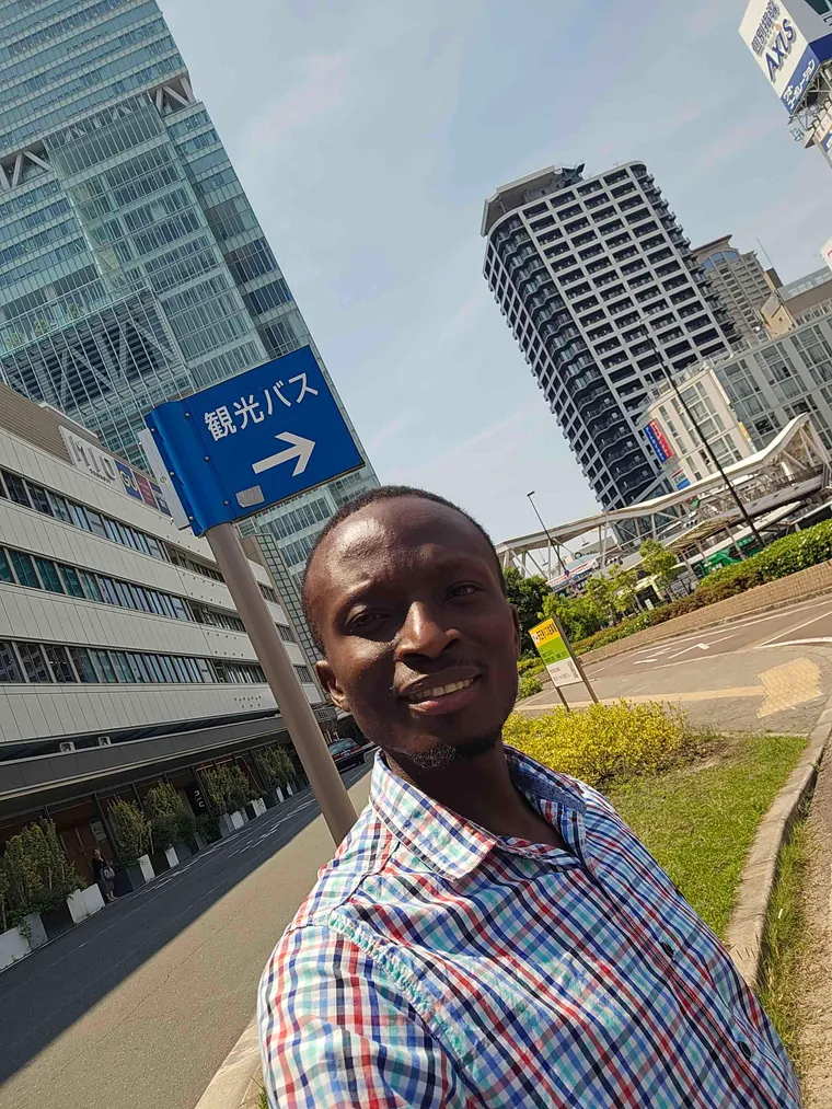 Peter Bamuhigire outside a city transit station