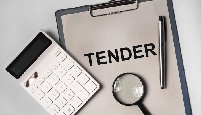 Tender document, calculator and magnifying glass representing institutional procurement readiness