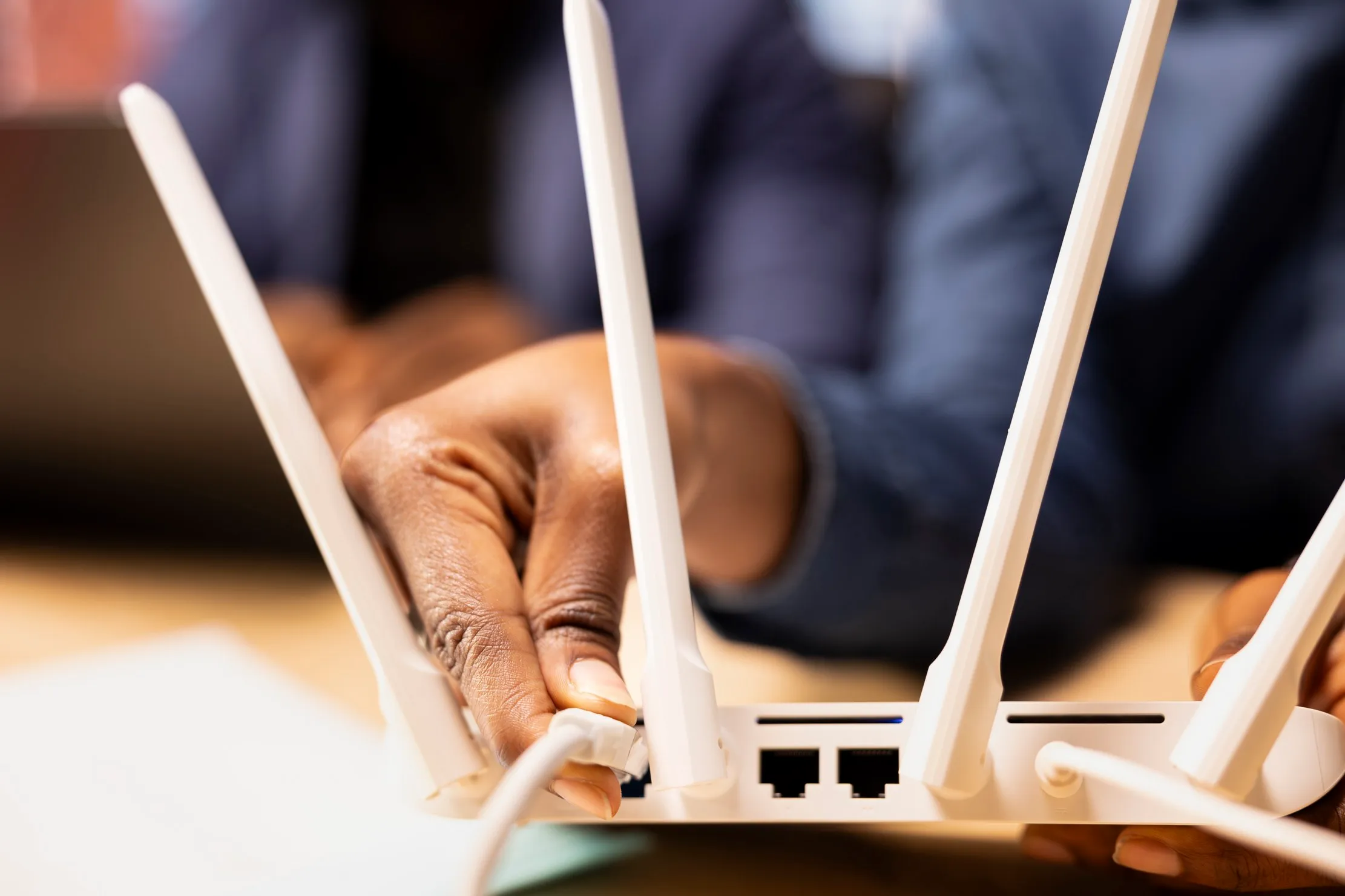 Technician connecting a network router and cable, representing careful branch installation and recovery work