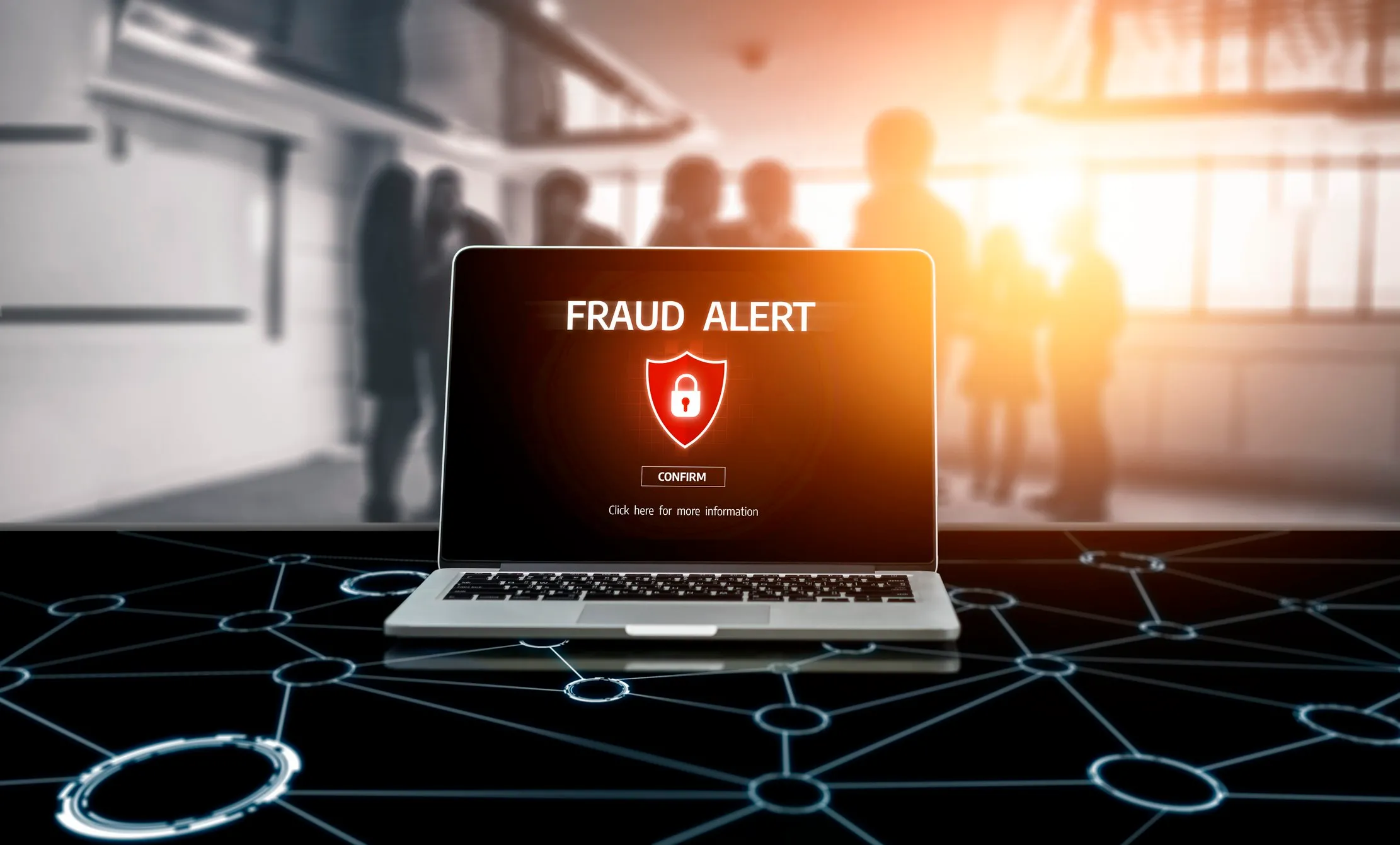Fraud alert displayed on a laptop in an office setting, representing a suspected phishing incident