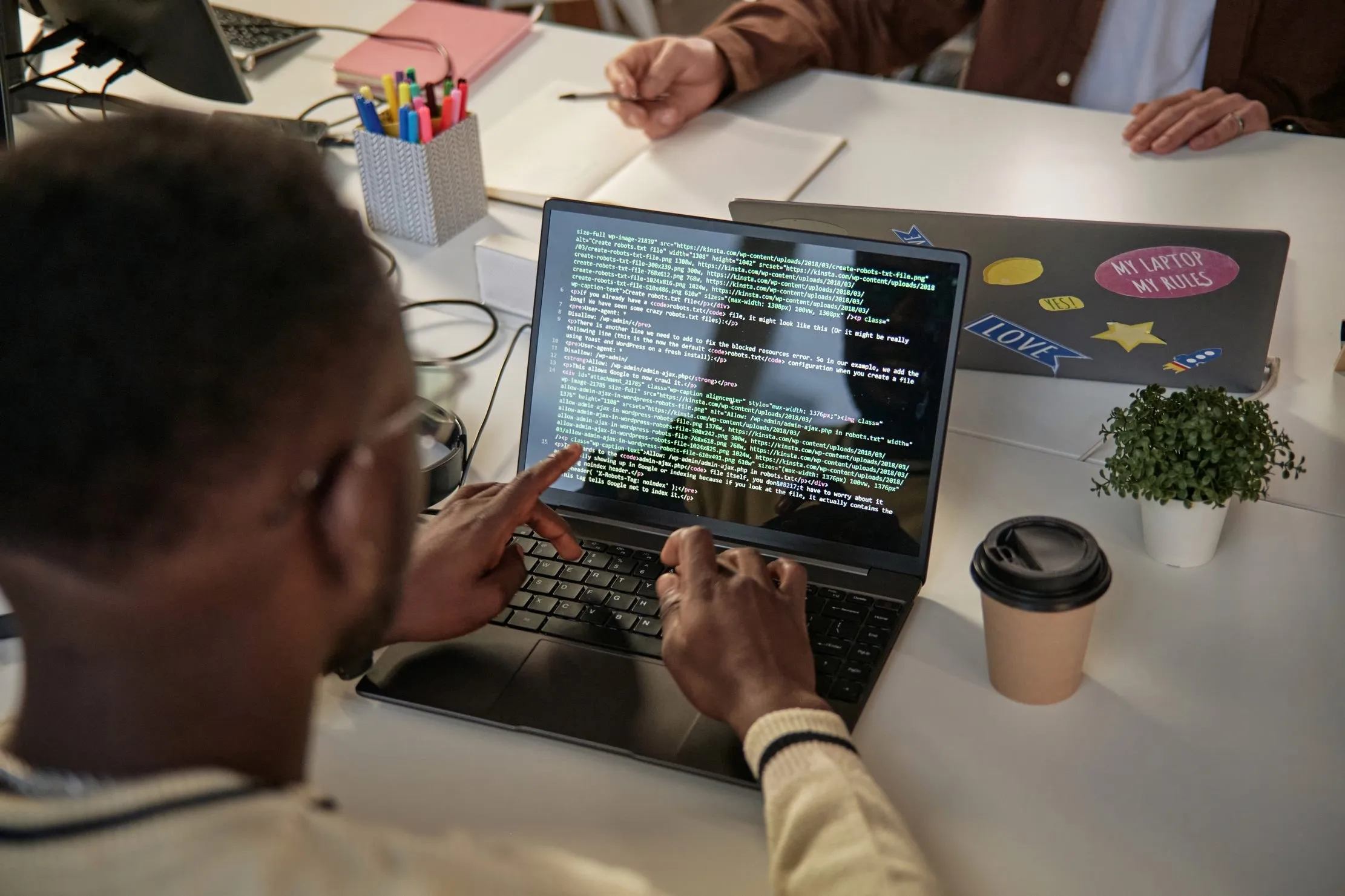 Software developer reviewing code on a laptop before a multi-country African system rollout
