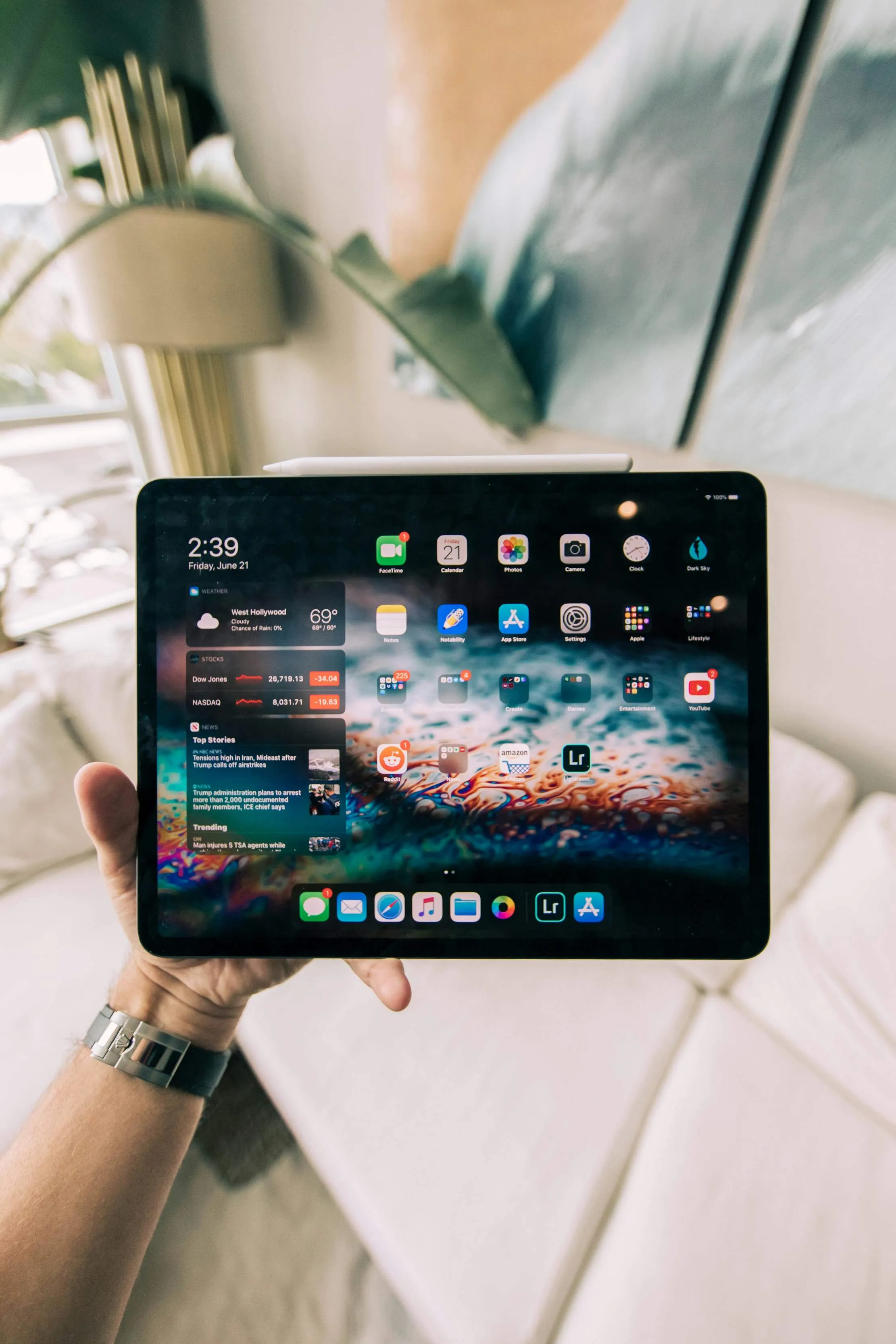 iPad held in one hand, representing adaptive iPadOS surfaces